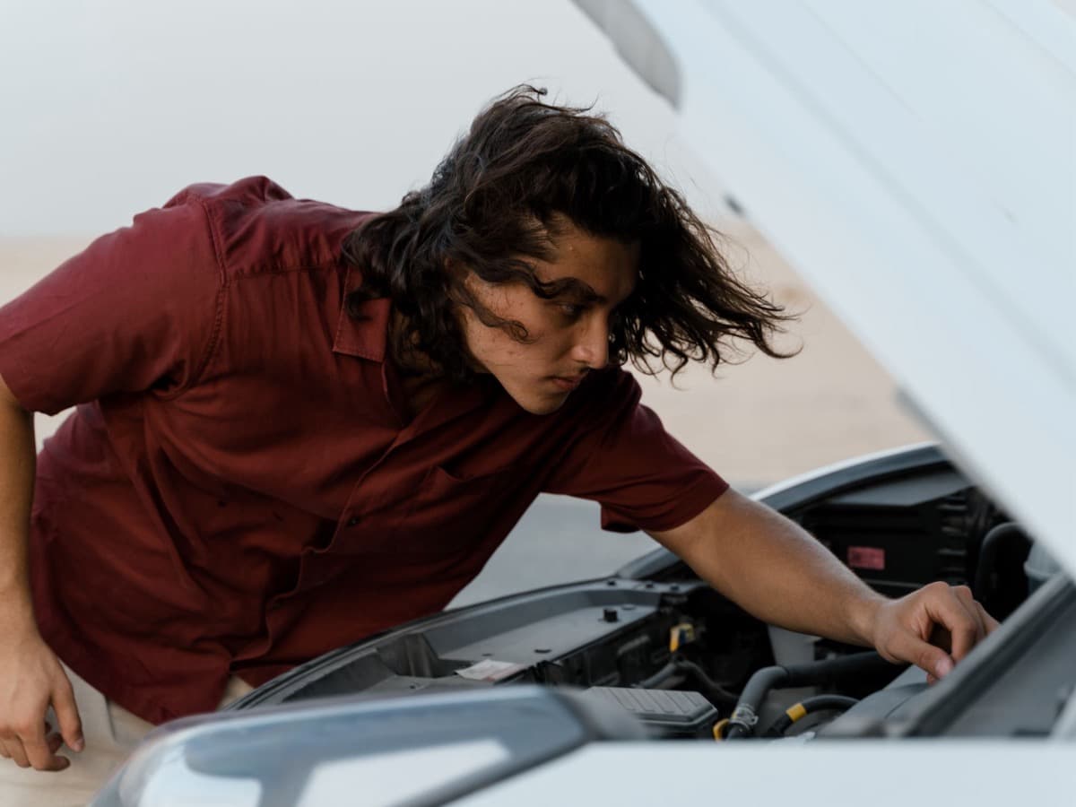 Checking the engine bay of a used car during an outdoor inspection